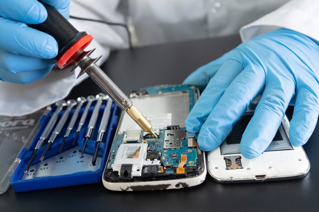 technician repairing inside mobile phone by soldering iron 39768 2652