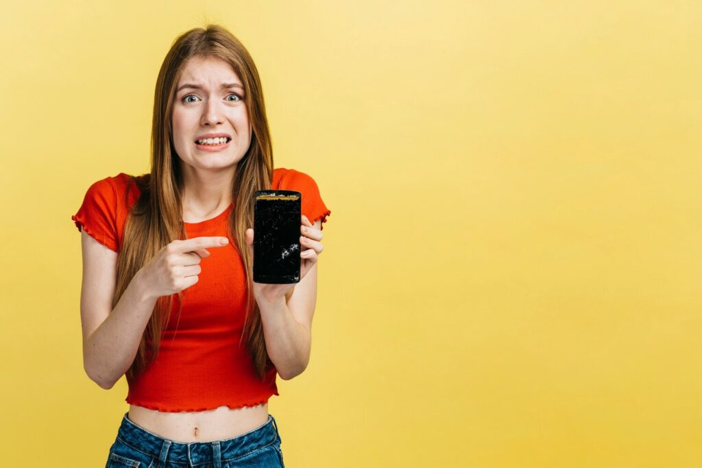 woman holding broken phone with copy space 23 2148221777 woman holding broken phone with copy space 23 2148221777